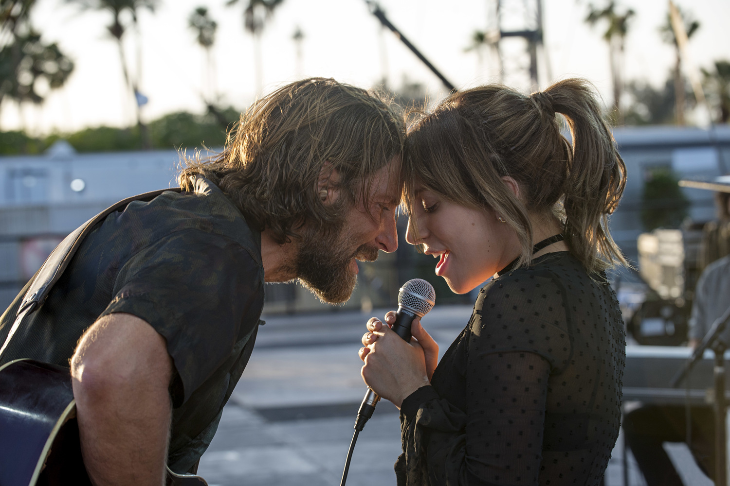 Les personnages incarnés par Lady Gaga et Bradley Cooper chantent en duo sur scène. Image issue du film "A star is born" réalisé par Bradley Cooper.