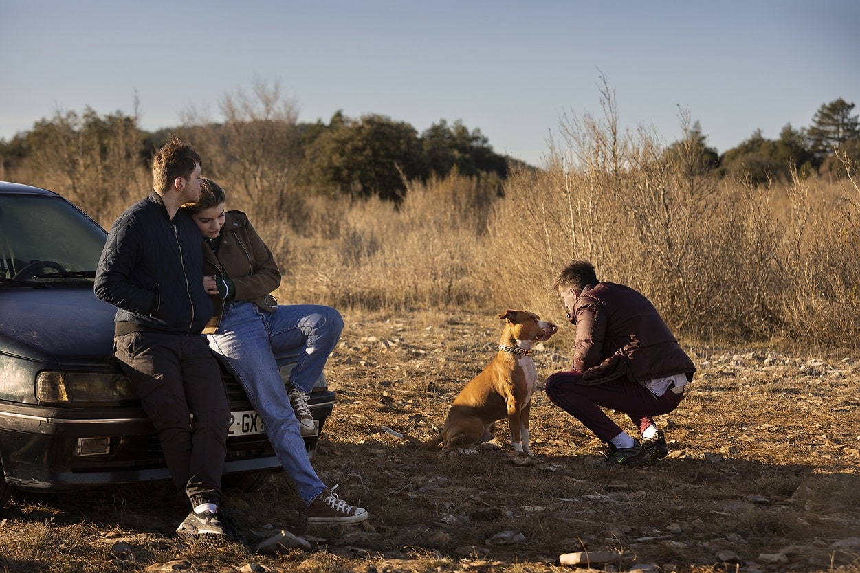 Les personnages incarnés par Anthony Bajon, Raphael Quenard et Galatea Bellugi au milieu de rien avec leur chien et leur voiture. Image issue du film "Chien de la casse" réalisé par Jean-Baptiste Durand.