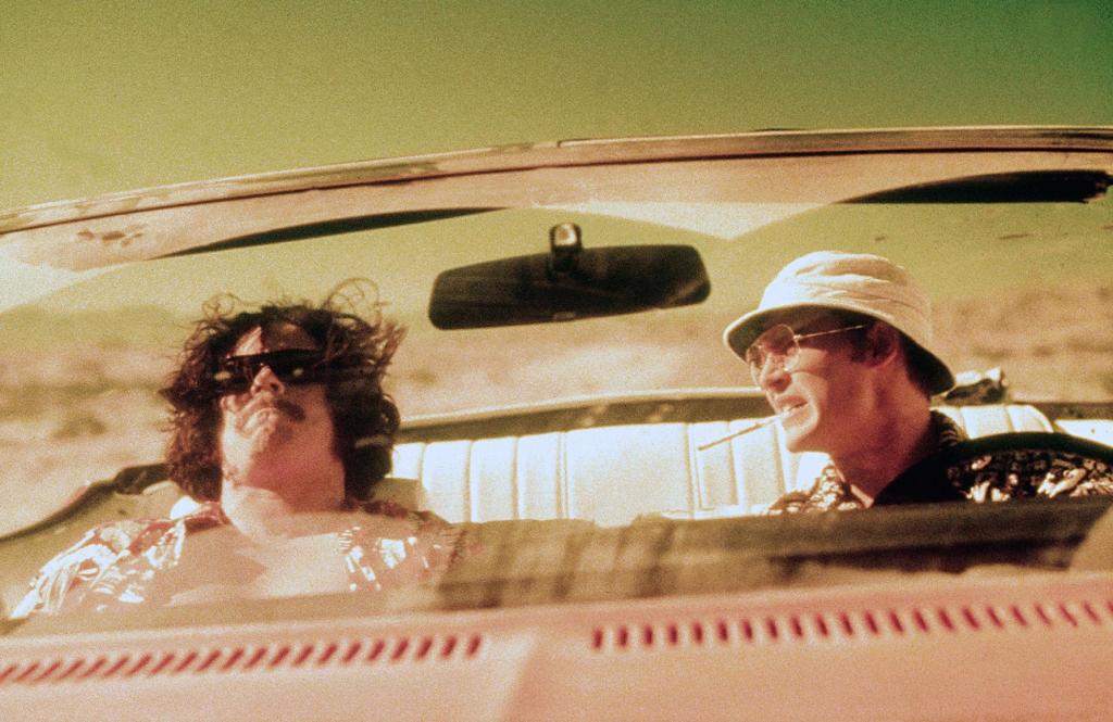 Benicio DelToro et Johnny Depp hilare au volant de leur cadillac dans le film Las Vegas Parano réalisé par Terry Gilliam.