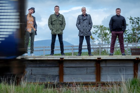 Les quatre héros de "Traispotting 2" posent devant une voie ferrée. Image issue du film "Trainspotting 2" réalisé par Danny Boyle.