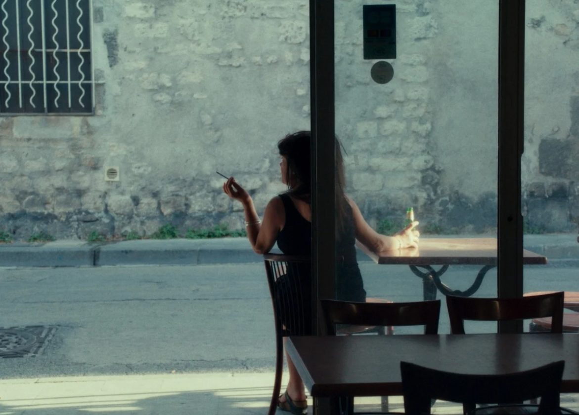 Nathalie la tenancière du bar sirote une boisson en terrasse. Image issue du film "Atlantic Bar" réalisé par Fanny Molins.